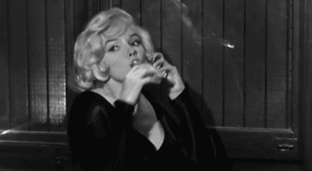 marilyn monroe smoking a cigarette and sitting down