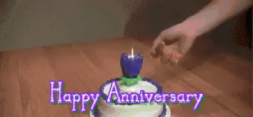 person placing candle on cake that says happy anniversary