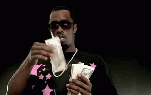 a man holding two stacks of money, wearing shades