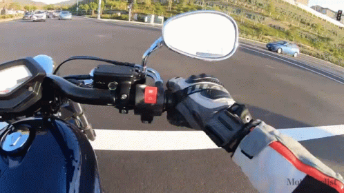 a reflection in the rear view mirror of a motorcycle