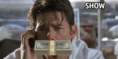 a person holding a stack of money to their face while talking on the phone