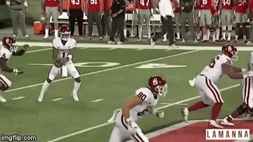 two football players run with the ball in hand