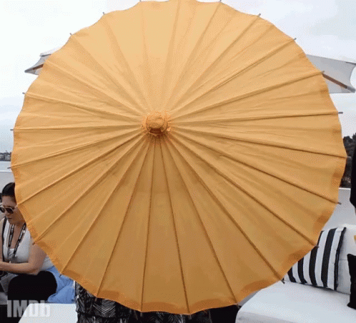 an open umbrella that is in front of some pillows
