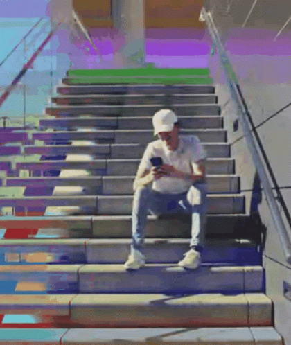 a man walking down a stairway that has colorful steps painted on it