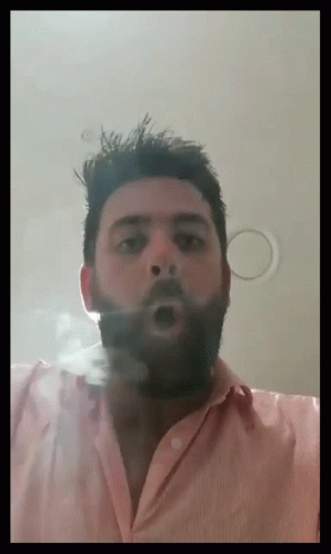 a man is blowing bubbles as he is making a funny face