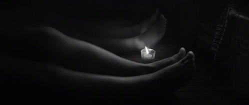 two hands holding the lighted candle in black and white