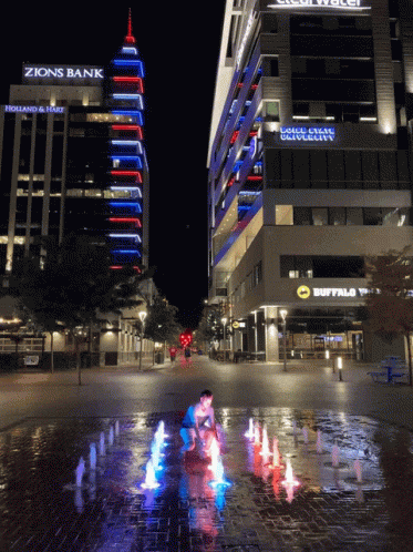 a fountain with colored lights on a city street