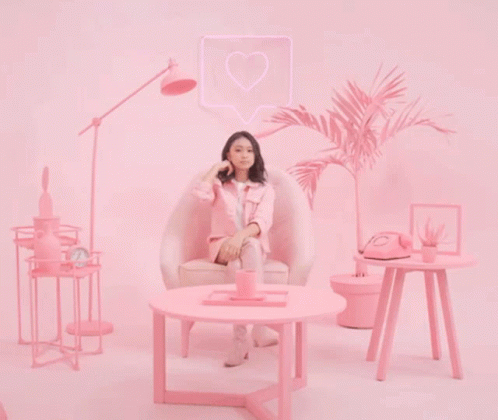 a girl sitting on a chair talking on a cell phone