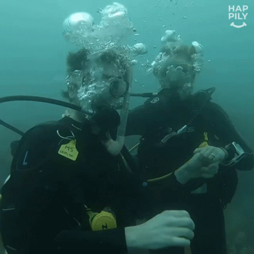 two scuba people wearing a wet suit looking very funny