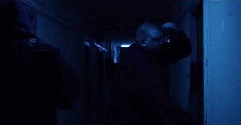 a man holding a phone in a dark hallway