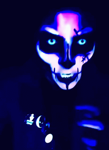 a masked person with glowing eyes, orange and black makeup