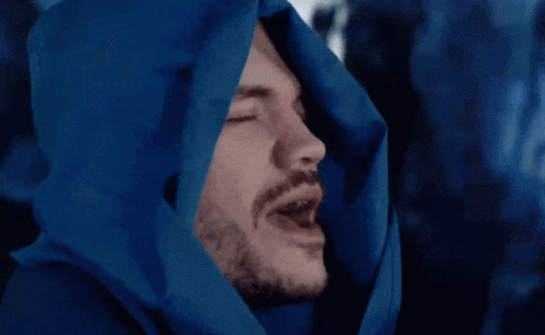 a man that is wearing a hood with a blue picture on it