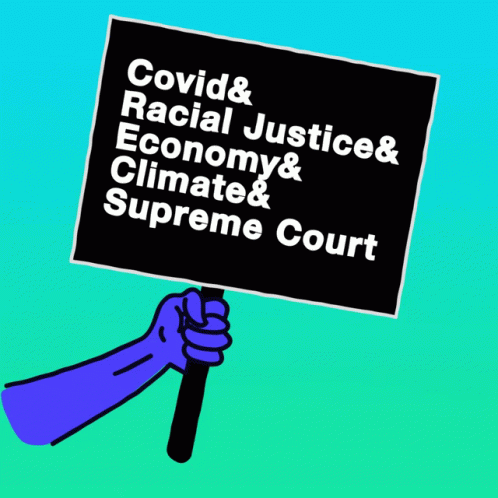 a hand holding a sign with words covidd, racist justice, economy and climate court
