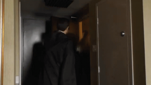 a creepy hooded man standing in a door way