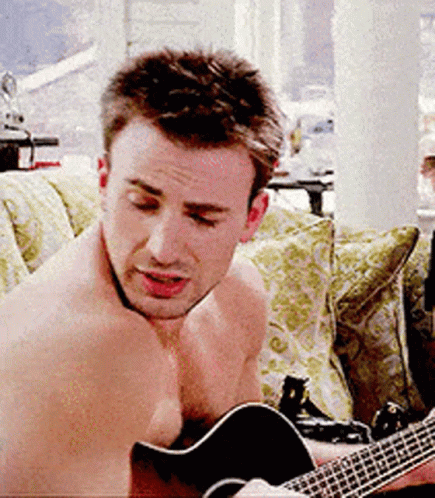 a shirtless man is playing the guitar