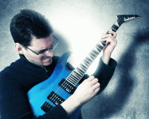 man playing an electric guitar while posing for a po