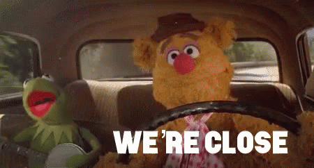 two sesame street characters in the back seat of a car, text reading we're close