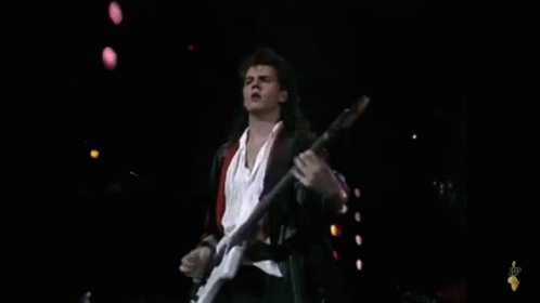 the young man is playing a guitar on stage