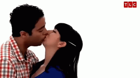 a young man kissing a young woman on the cheek