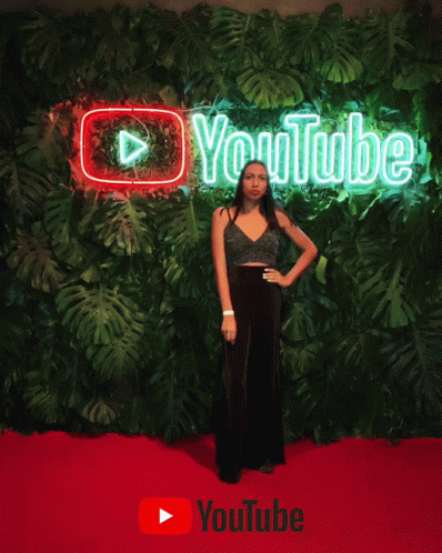 woman posing in front of the youtube logo