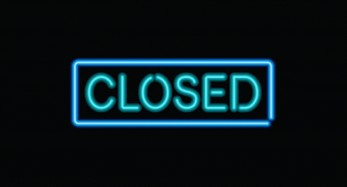 a neon closed sign in the dark