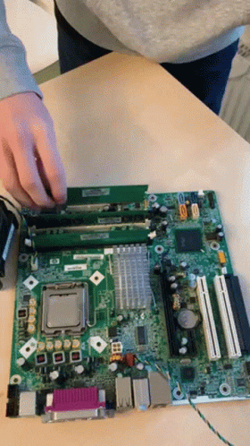 a person removing the motherboard from a laptop computer
