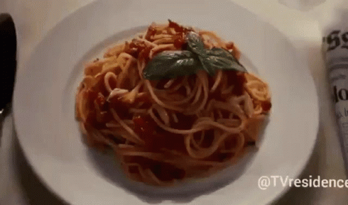 a plate of spaghetti and sauce on a table