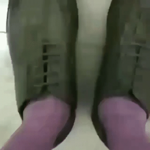 person in purple pants and green shoes with their feet on the floor