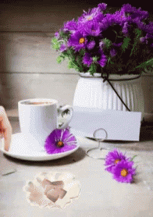 a teapot and flower bouquet, which has been placed next to an empty coffee cup