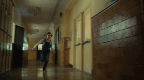 a lady that is running in the middle of a hallway