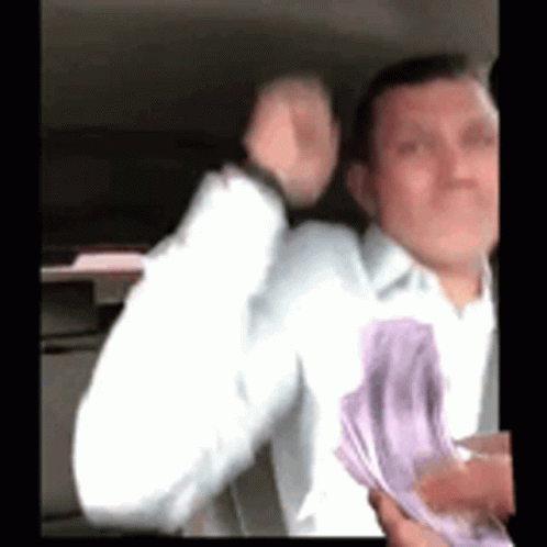 a guy in a car that is playing with paper