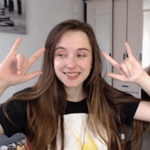 a girl making peace signs with her fingers