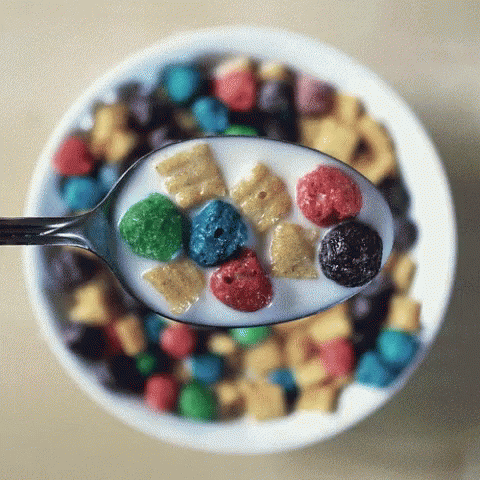 a spoon full of cereal sits in a bowl