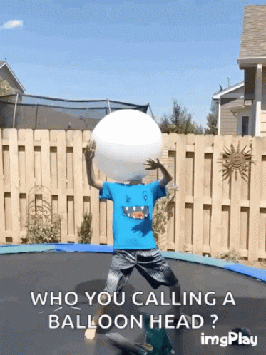 a boy juggles a ball on top of an upside down trampol