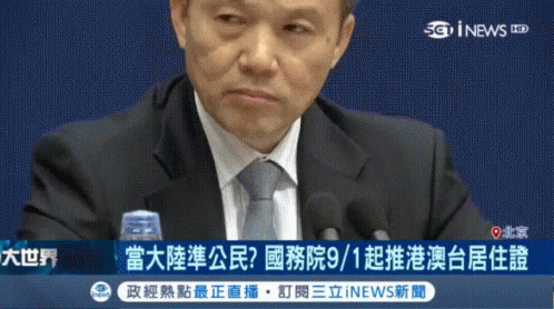 a man in a suit sits down at a news conference