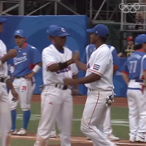the men are standing together in the middle of a baseball game