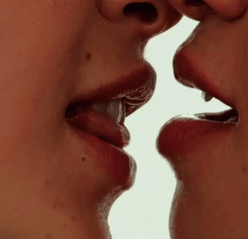 a woman with her mouth open looking at another lady with a ring on her right and blue lips and cheek to cheek