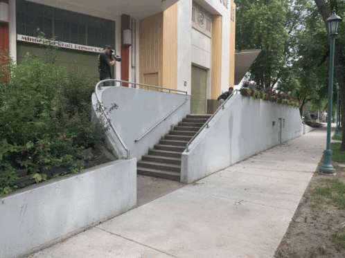 the front stairs to the building lead up from the sidewalk