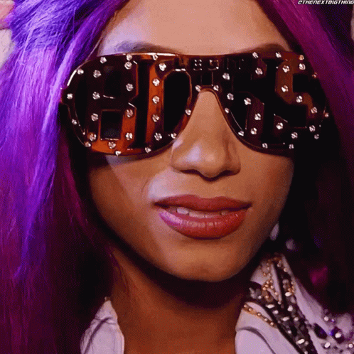 a lady wearing sunglasses with bright hair and blue makeup