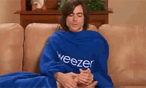 a man wrapped up sitting on a blue couch
