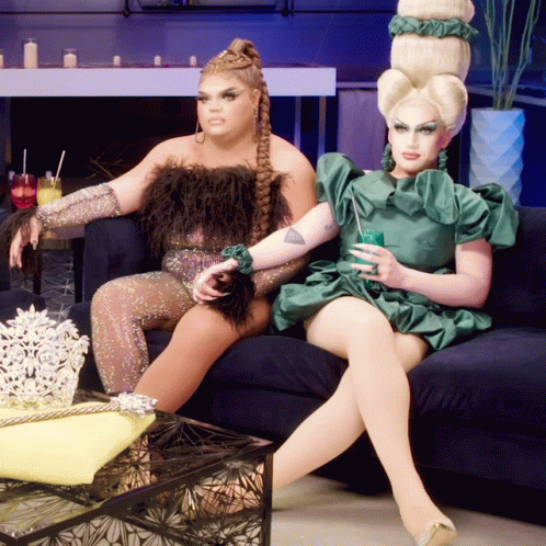 two woman dressed as women sitting on a couch