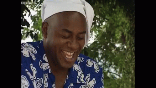an african american man wearing a blue and white dress shirt laughing