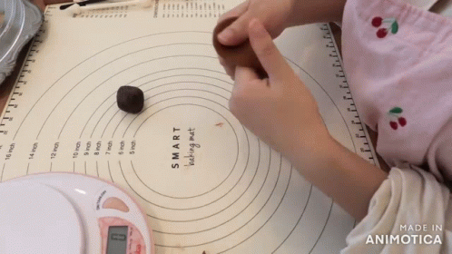 a person measuring the measurement sheet next to their work