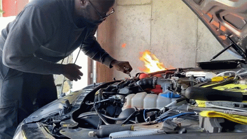a mechanic repairing an automobile's engine in his garage