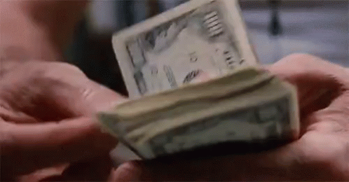 a hand holding a small paper currency