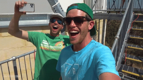 two people in green and yellow shirts with sunglasses on