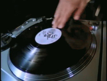 a person is pressing a vinyl onto the turntable
