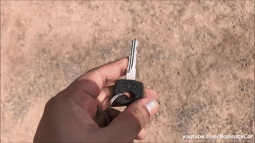 someone holding up a tiny key on a keychain