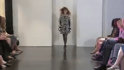 a girl walks the runway in a ze print dress