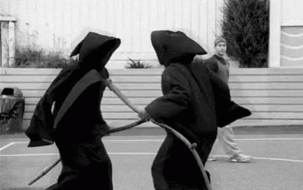 two people wearing black robes playing tennis together